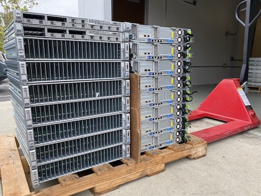 A stack of servers on a pallet in a warehouse.